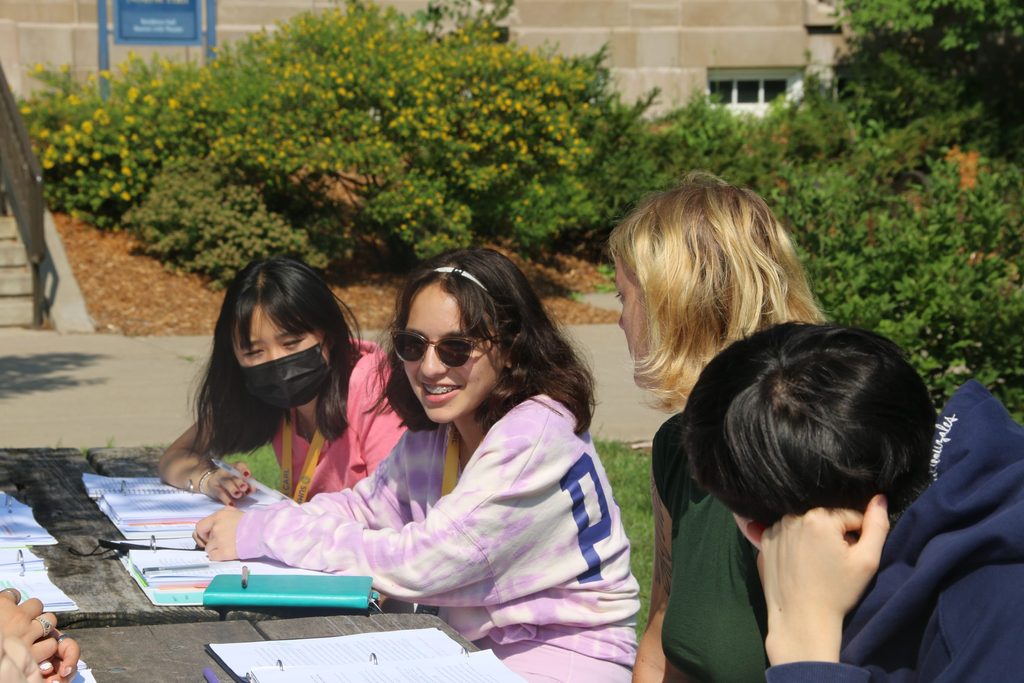 Global Pandemics students engage in discussion around a picnic table