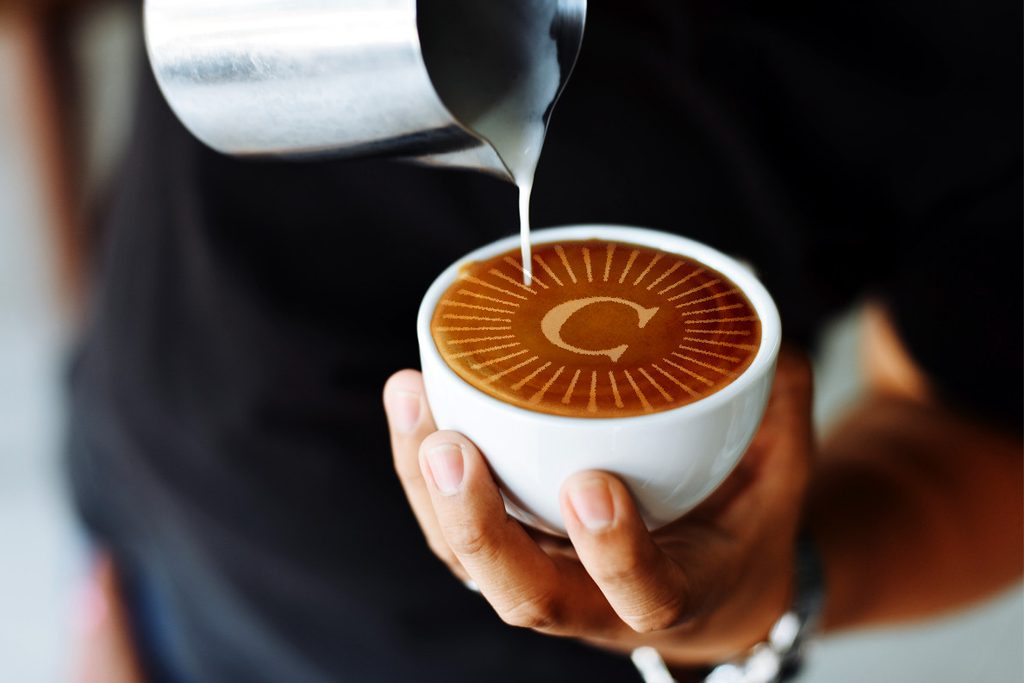 Coffe cup with foam in the shape of a Carleton logo