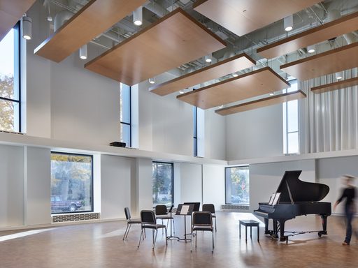 Image of Shackel Hall, a Music Dept. rehearsal space, with a piano, music stands, and chairs.