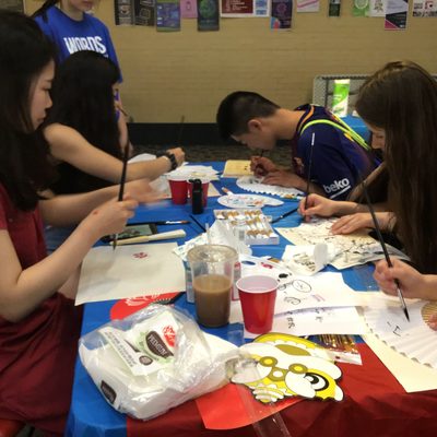 a group of students painting at a table