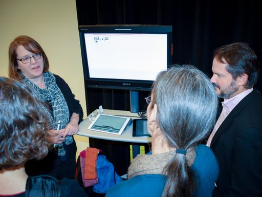 image of Deborah Gross with technology visible talking to colleagues