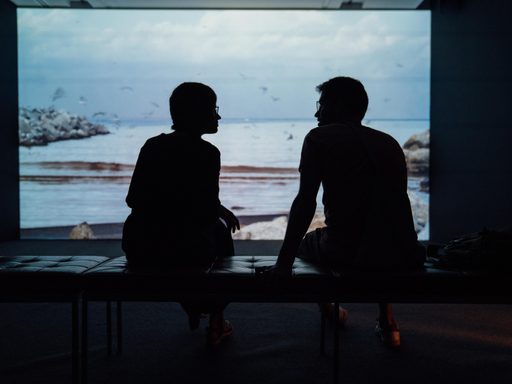 Silhouette of two people talking
