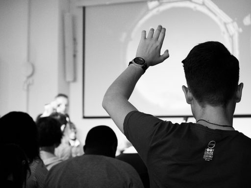 Student raising his hand in the classroom