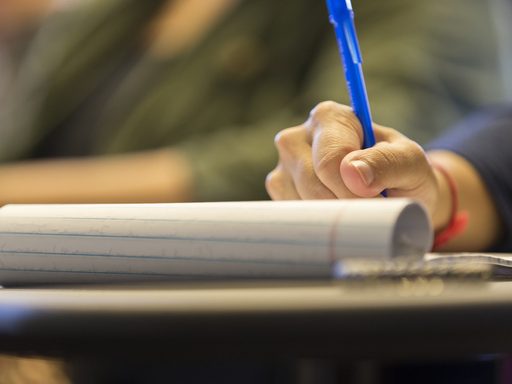 student writing on a notepad