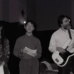 Two students sing while Mark Plays guitar.