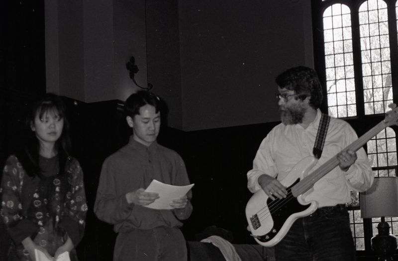 Two students perform with Mark playing guitar.