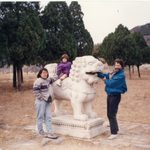 3 people posing with Chinese stone animal sculpture.