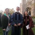 Three people posing outside the chapel
