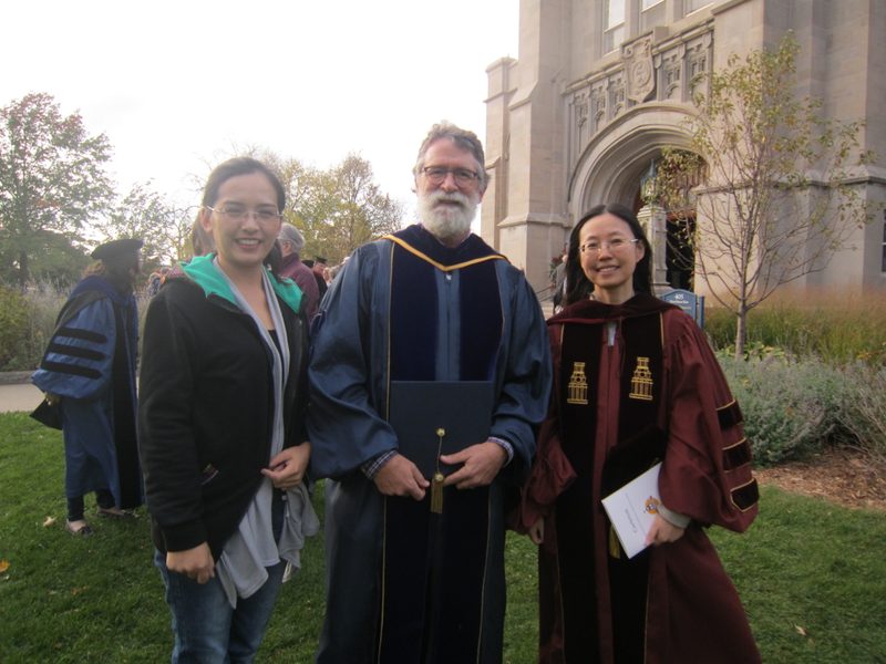 Three people posing outside the chapel