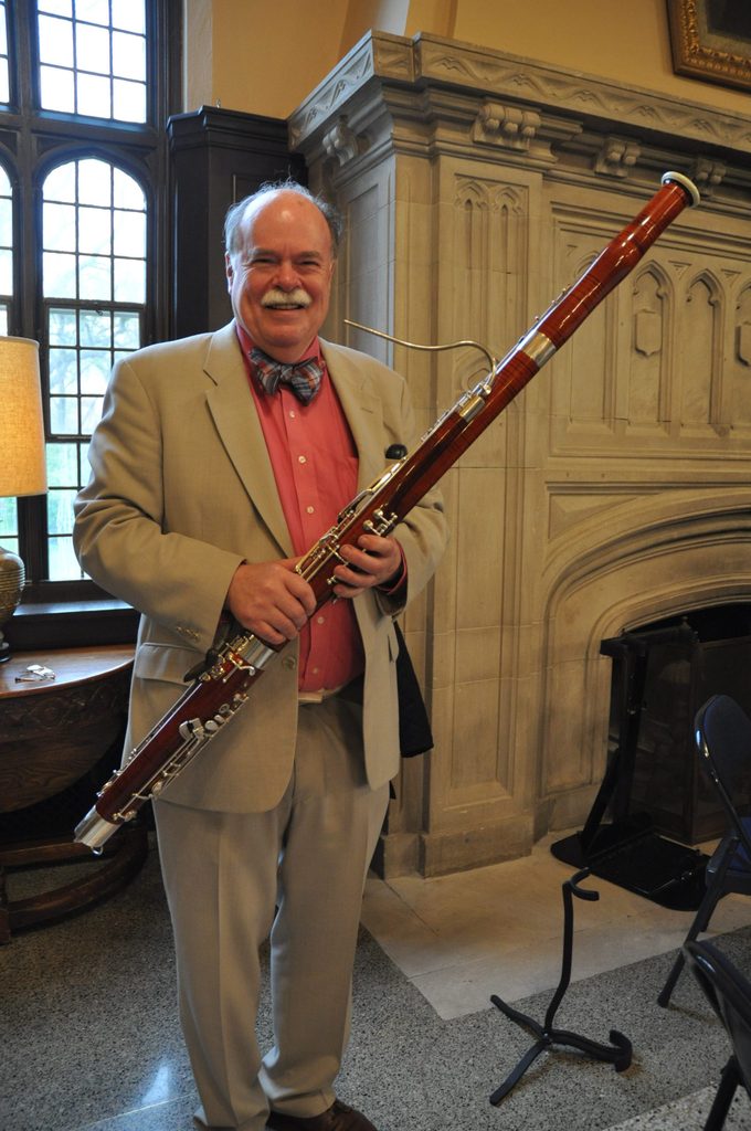 Jack Bryce standing in front of a fireplace holding his bassoon.
