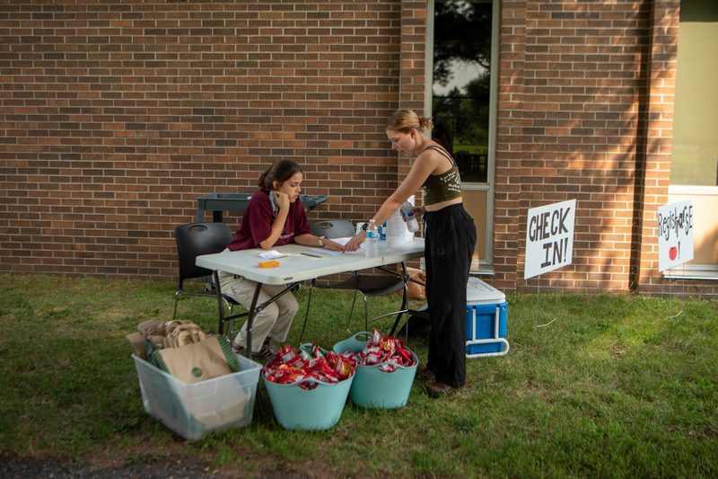 Carleton students Tali Emlen and Colleen Mulligan working at the Farm to Family market.