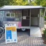 a small silver trailer with an info sign