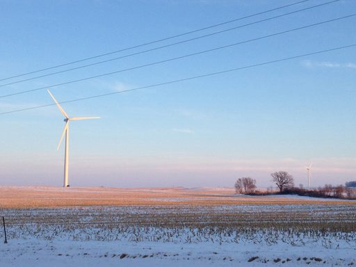 A windmill in a winter field.