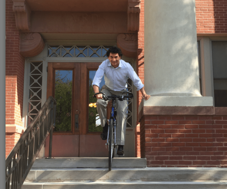 Peter Balaam, Associate Professor of English, rides down the steps of Laird Hall