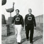 Jack Caton ’40 and Paul Clifford Domke ’40 walk along the mission wall.