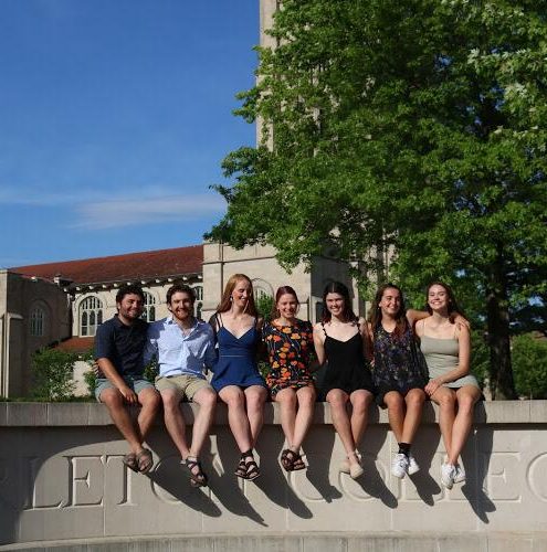 seven people sit at the entrance to Carleton College