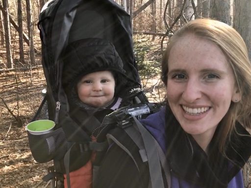 woman wearing a backpack with a baby in it