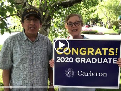 parents holding a congratulations sign