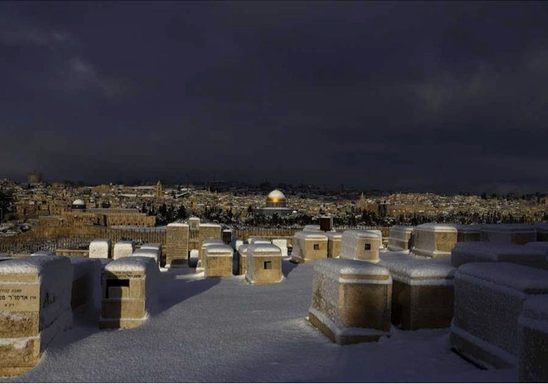 A snowy graveyard on a Jerusalem hilltop