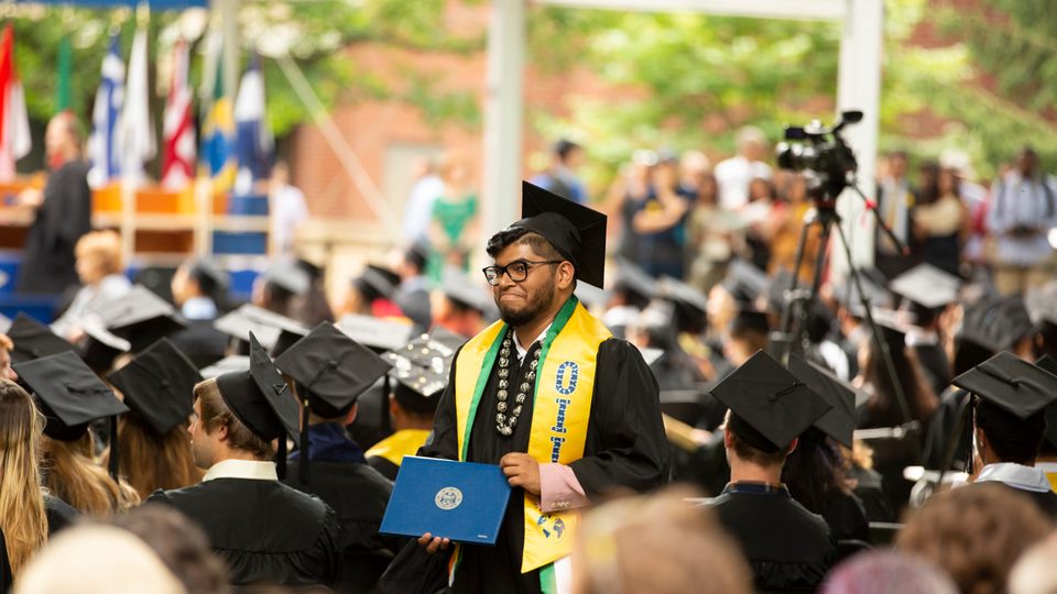 A student receives his diploma at Carleton's 2019 commencement ceremony.