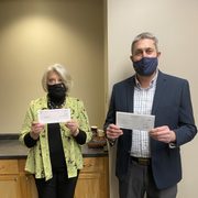 Carleton Vice President and Treasurer Eric Runestad and St. Olaf Vice President and Chief Financial Officer Janet Hanson present the colleges' annual donation to the City of Northfield