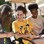 students smile on a golf cart