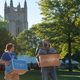 A student and adult with moving boxes with the chapel in the background.