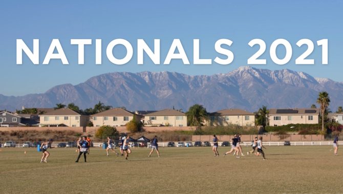 Ultimate frisbee players run on a field with a mountain backdrop.