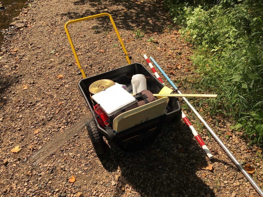 A wheelbarrow filled with equipment for researching pea clams.