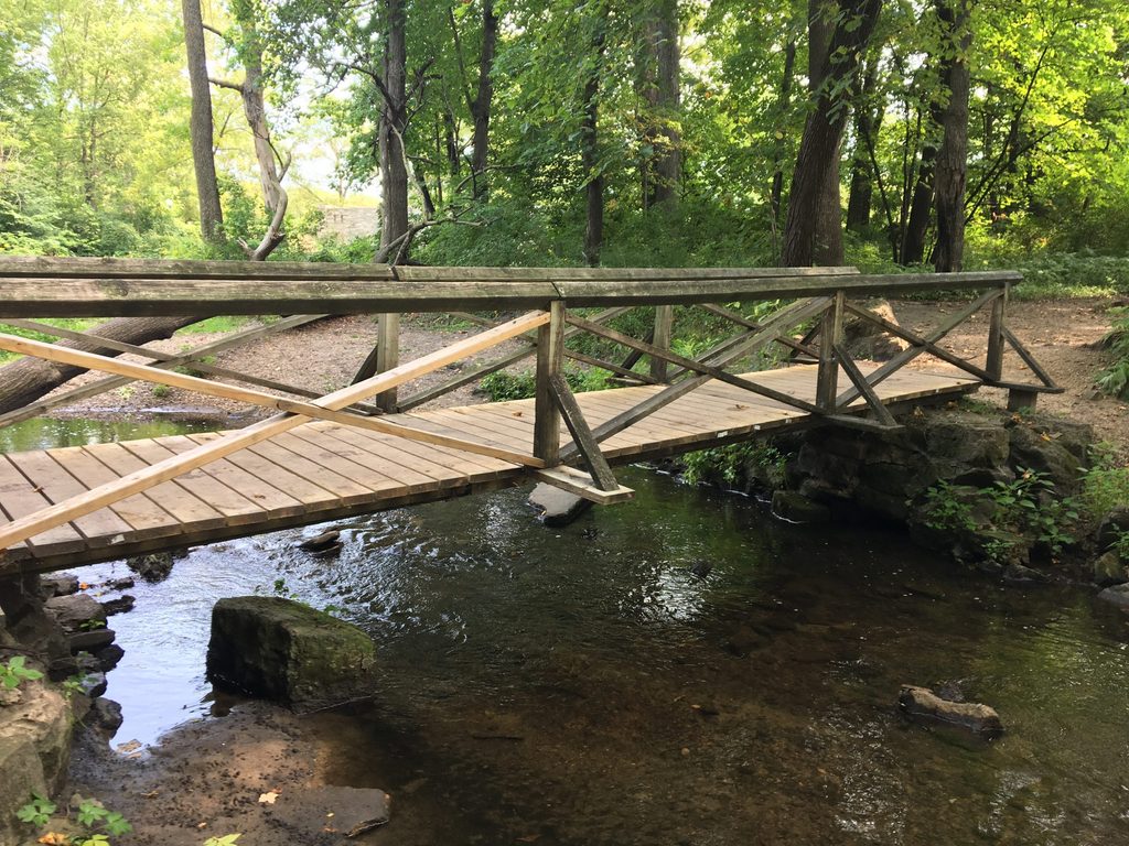 Un pod de lemn peste un mic pârâu.