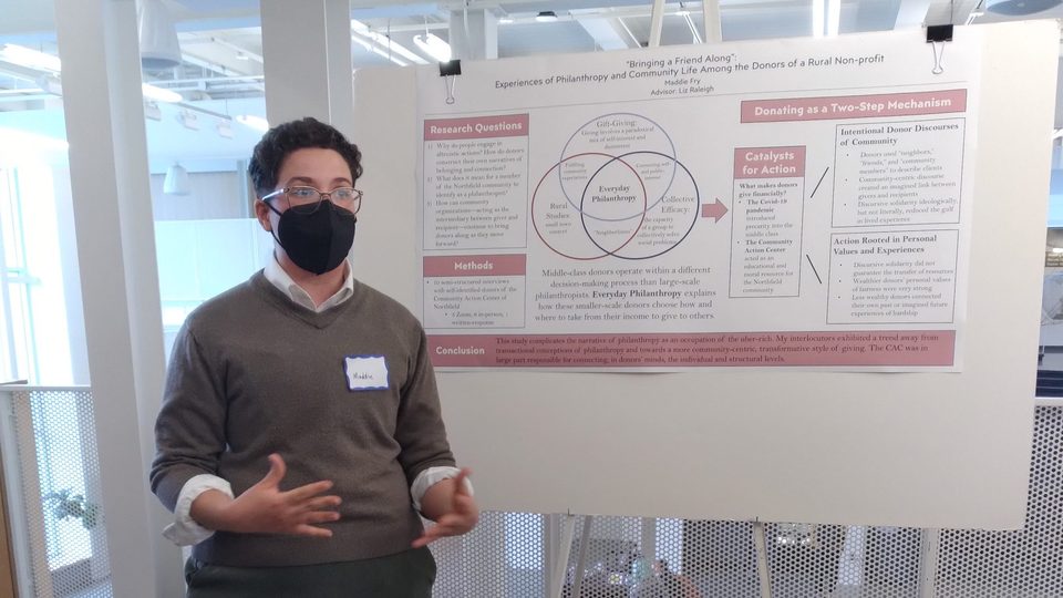 Maddie Fry '22 presents their comps research on a large poster board.