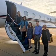 The 5 people in the 2016 cohort of Weitz Fellows poses on the steps to the Weitz family's private plane.