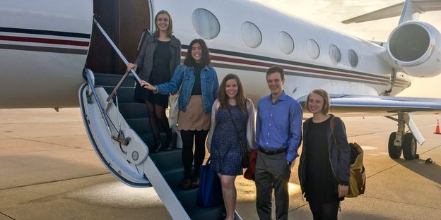 The 5 people in the 2016 cohort of Weitz Fellows poses on the steps to the Weitz family's private plane.