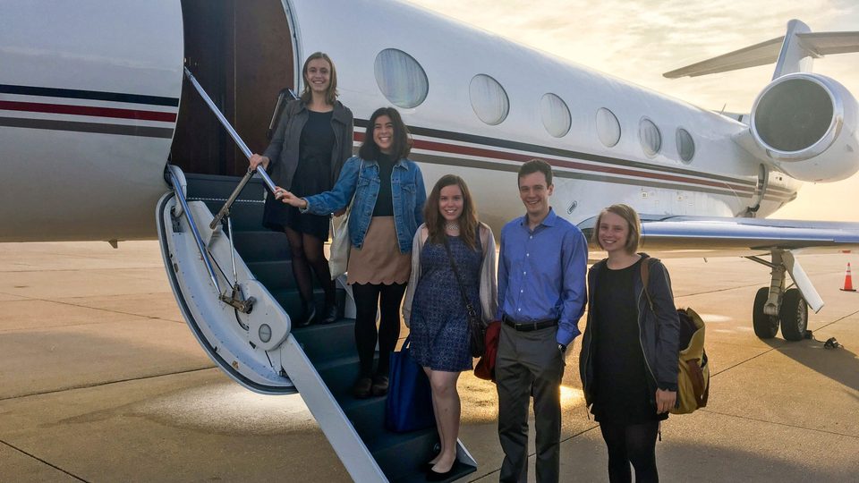 The 5 people in the 2016 cohort of Weitz Fellows poses on the steps to the Weitz family's private plane.