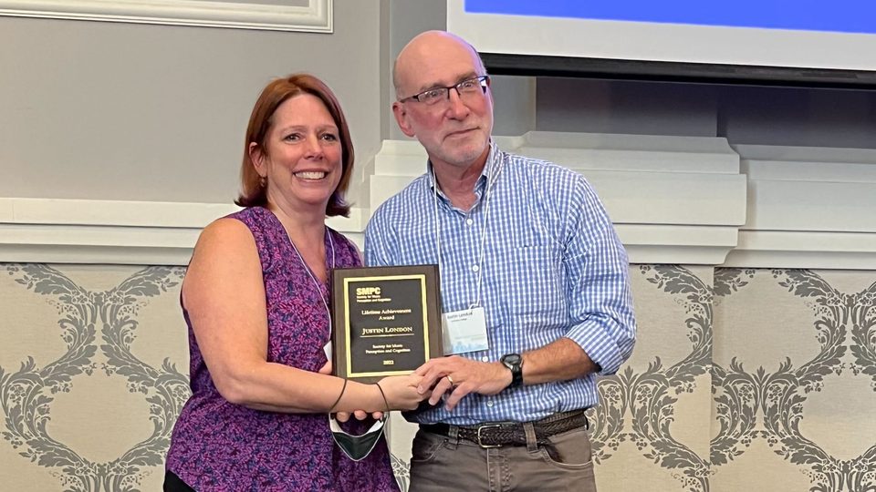 Leigh VanHandel and Justin London present London's Lifetime Achievement Award to the camera.