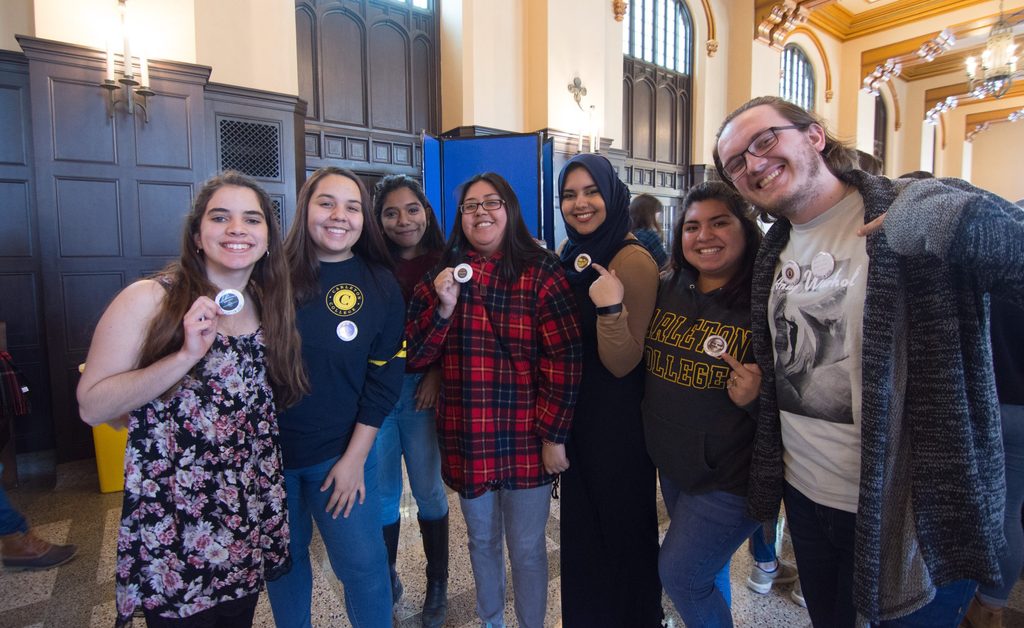 Seven students hold up buttons proclaiming their major in the Great Hall during the 2018 Major Declaration Day.