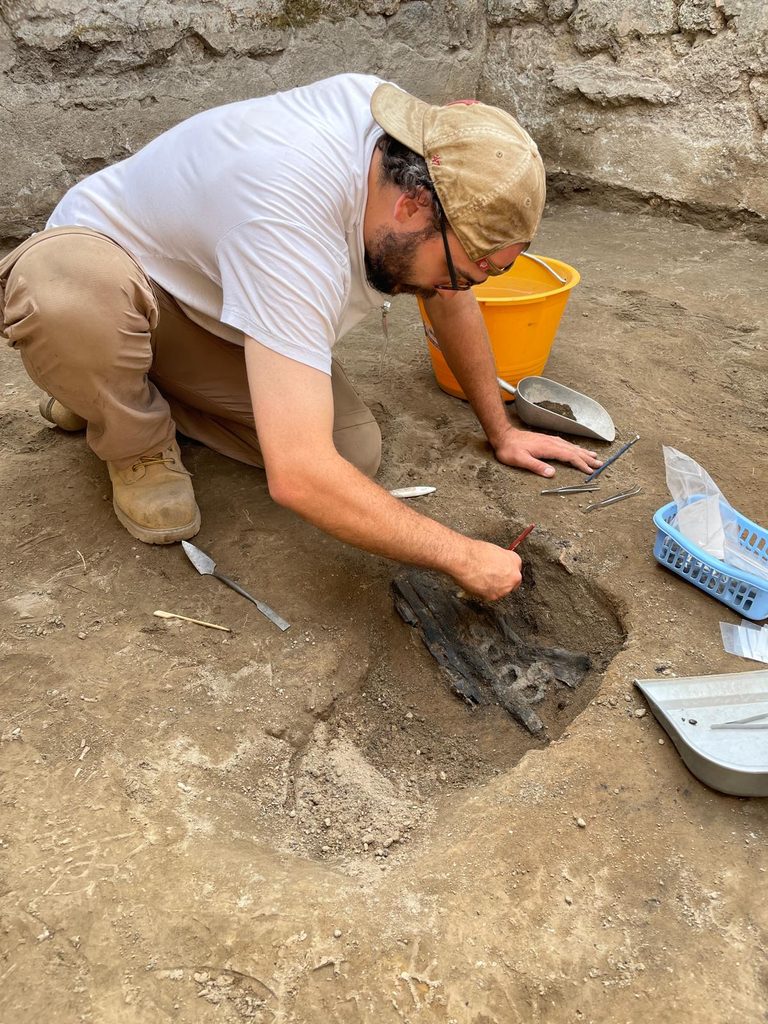 Professor Jordan Rogers excavates in a trench in Pompeii.