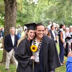 Cee Scallen '20 and Jez Bigornia '20 hug and pose with a sunflower for a different camera.