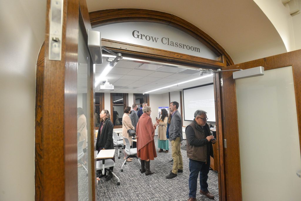 People mill around the Roy Grow classroom. Photo taken from outside the classroom.