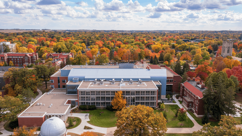 Aerial shot of campus with Olin Hall and the rest of the integrated science complex in the forefront. The trees are all orange, red and yellow.
