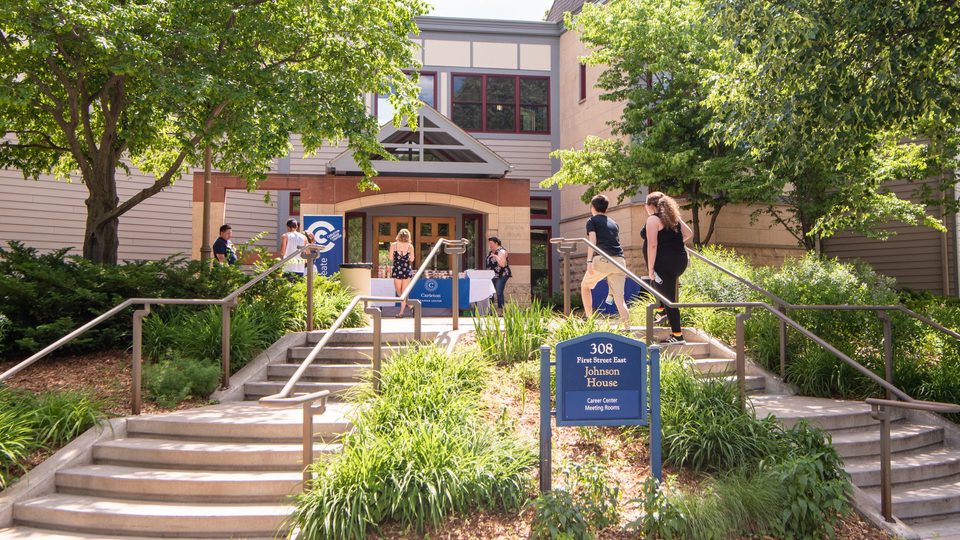 Students walk up the front steps and into the entrance of Johnson House.