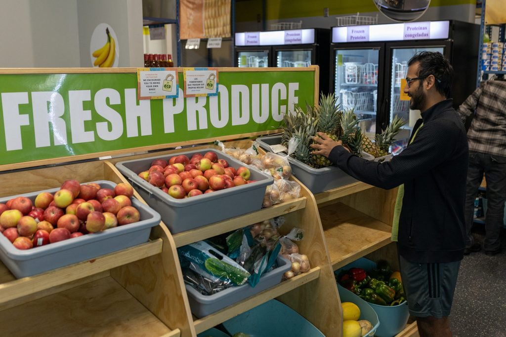 A student sorts produce at a food shelf.