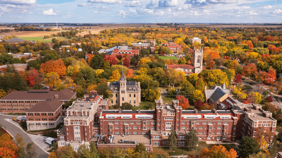 Aerial photo of campus with Burton in the foreground and the view stretching all the way past the wind turbines in the distance.