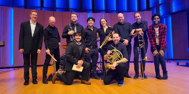Copper Street Brass pose with students onstage in Kracum.
