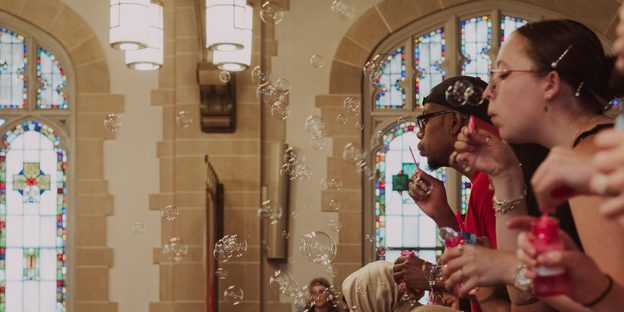 Students blow bubbles from the Chapel balcony.