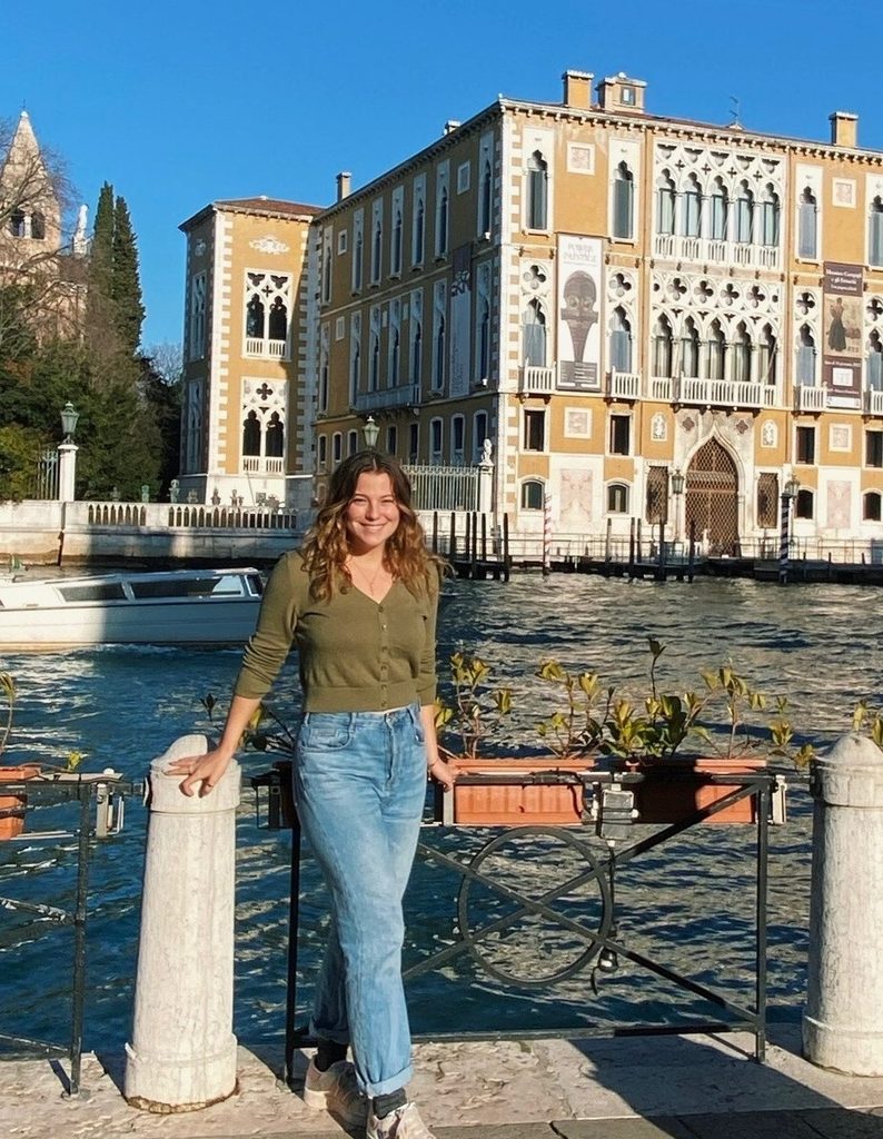 Sadie Ray Smith ’23 standing next to a river in a town.