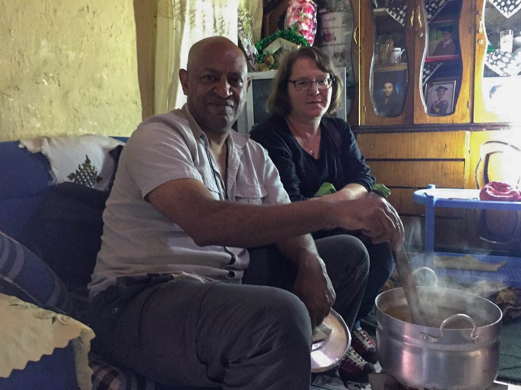 Professors Tsegaye Nega and Deborah Gross sit together on a couch.