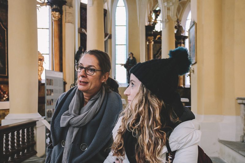 Student and Professor talking while in an old church