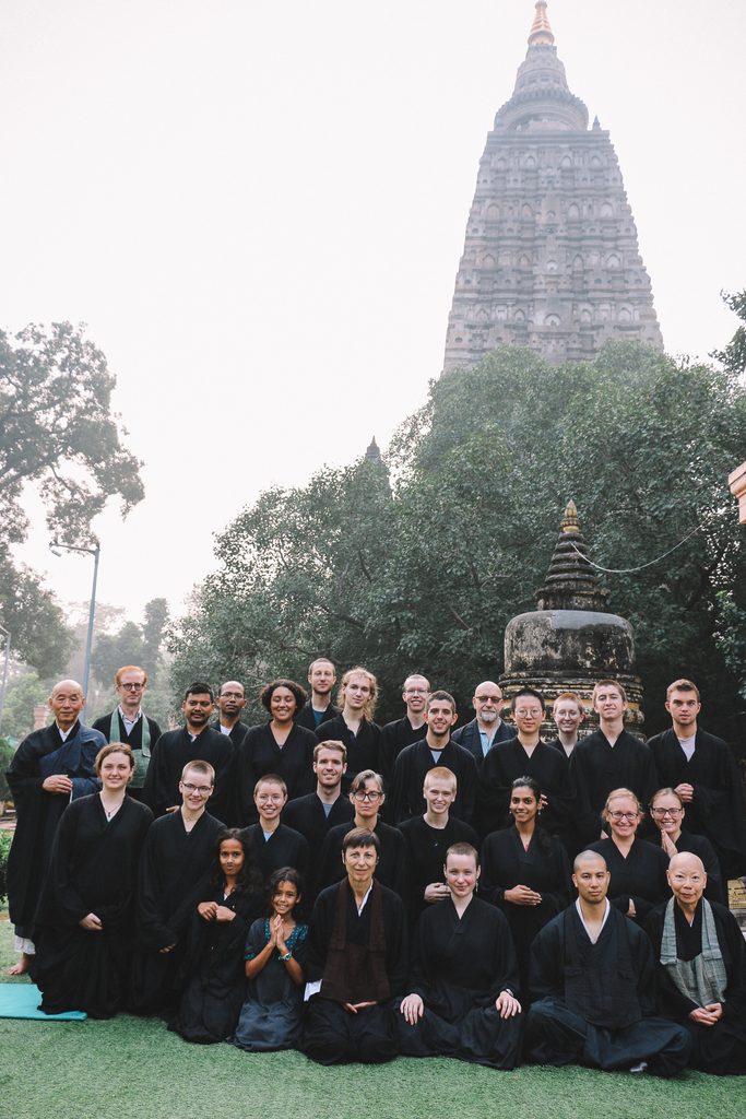 Participants pose in front of temple in meditation clothing