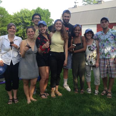 Students and professors pose for a photo in front of a barn